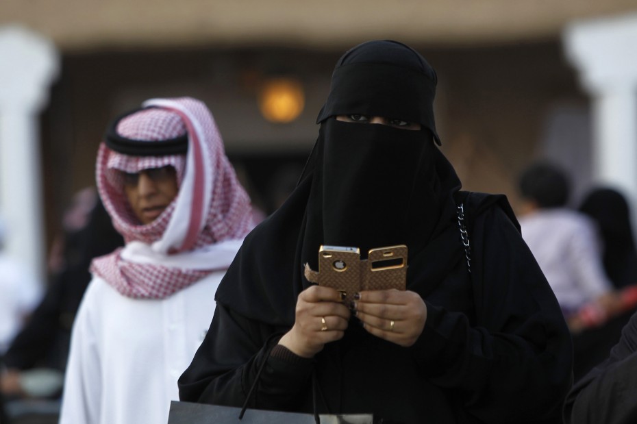 A woman using an iPhone visits the 27th Janadriya festival on the outskirts of Riyadh
