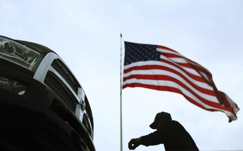 An auto carrier driver unloads a new Ram pickup truck in Gaithersburg, Maryland