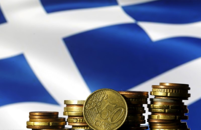 Euro coins are seen in front of a displayed Greece flag in this picture illustration