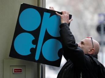 A man fixes a sign with OPEC's logo next to its headquarter's entrance before a meeting of OPEC oil ministers in Vienna