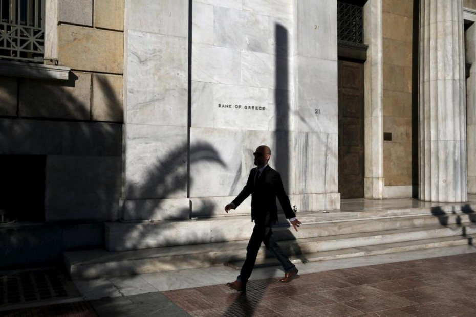 A man walks past the headquarters of Bank of Greece in Athens
